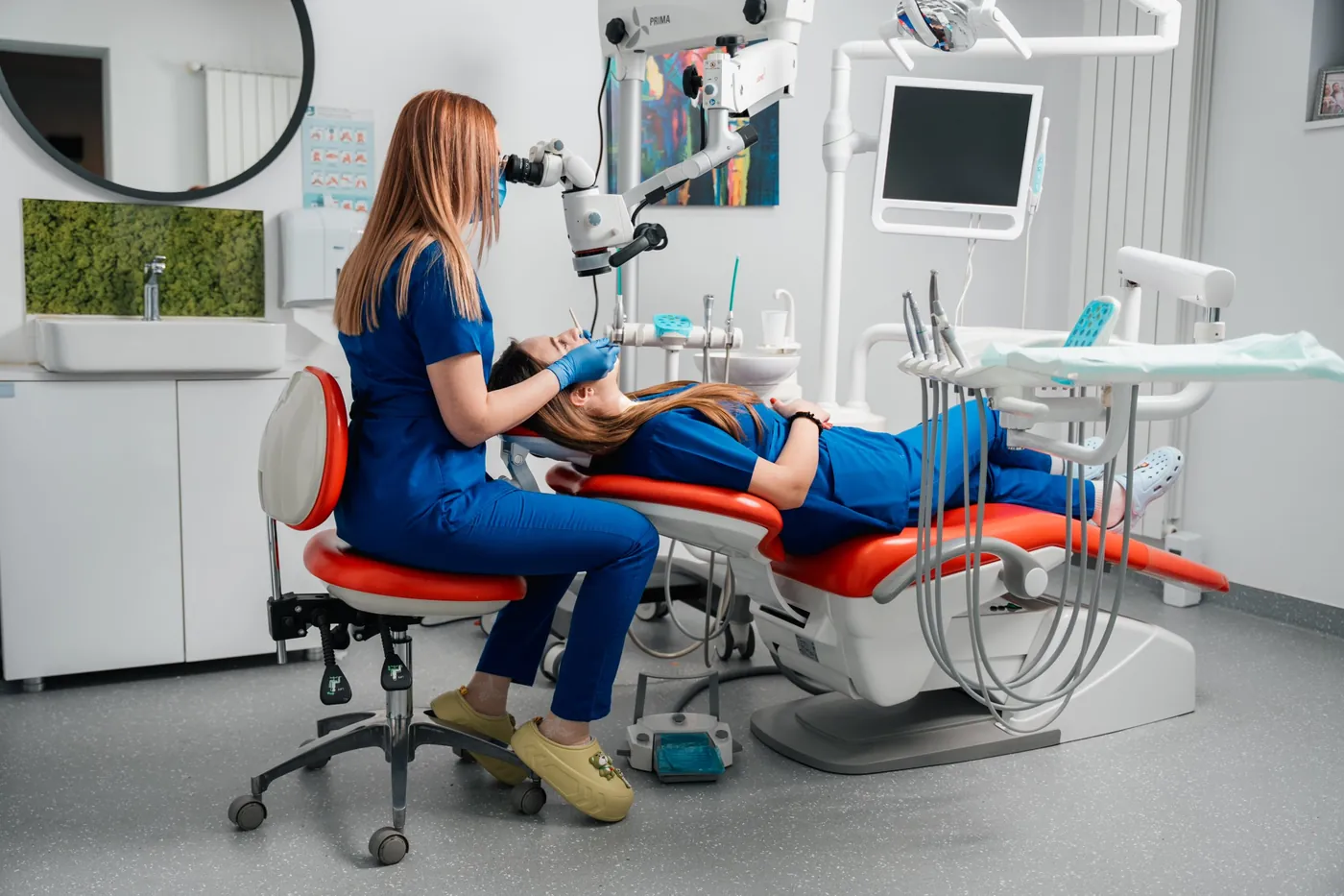 Medic endodont la microscop, în timpul unui tratament, într-un cabinet Toot Studio Dentar